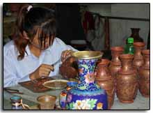 une Chinoise travaille à la confection d'un vase en cloisonné